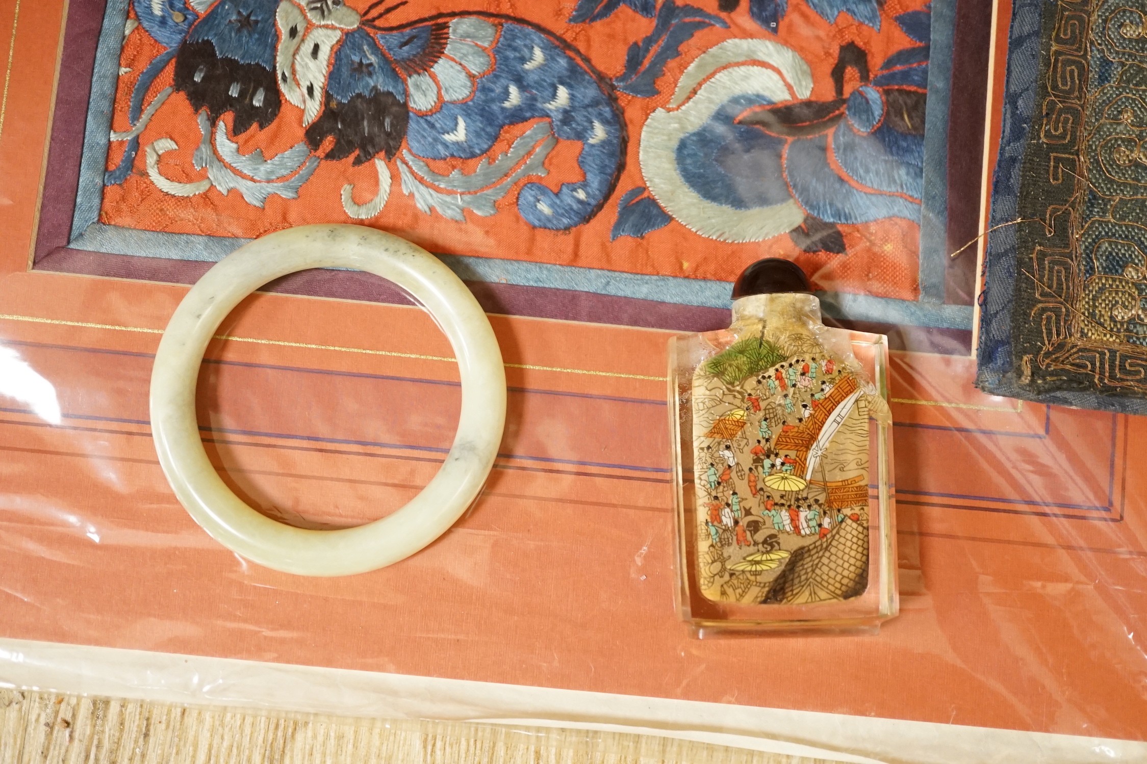 A Chinese embroidered silk Rank badge, mounted on a board, an inside painted snuff bottle, jade type bangle and a Chinese needlework pictures